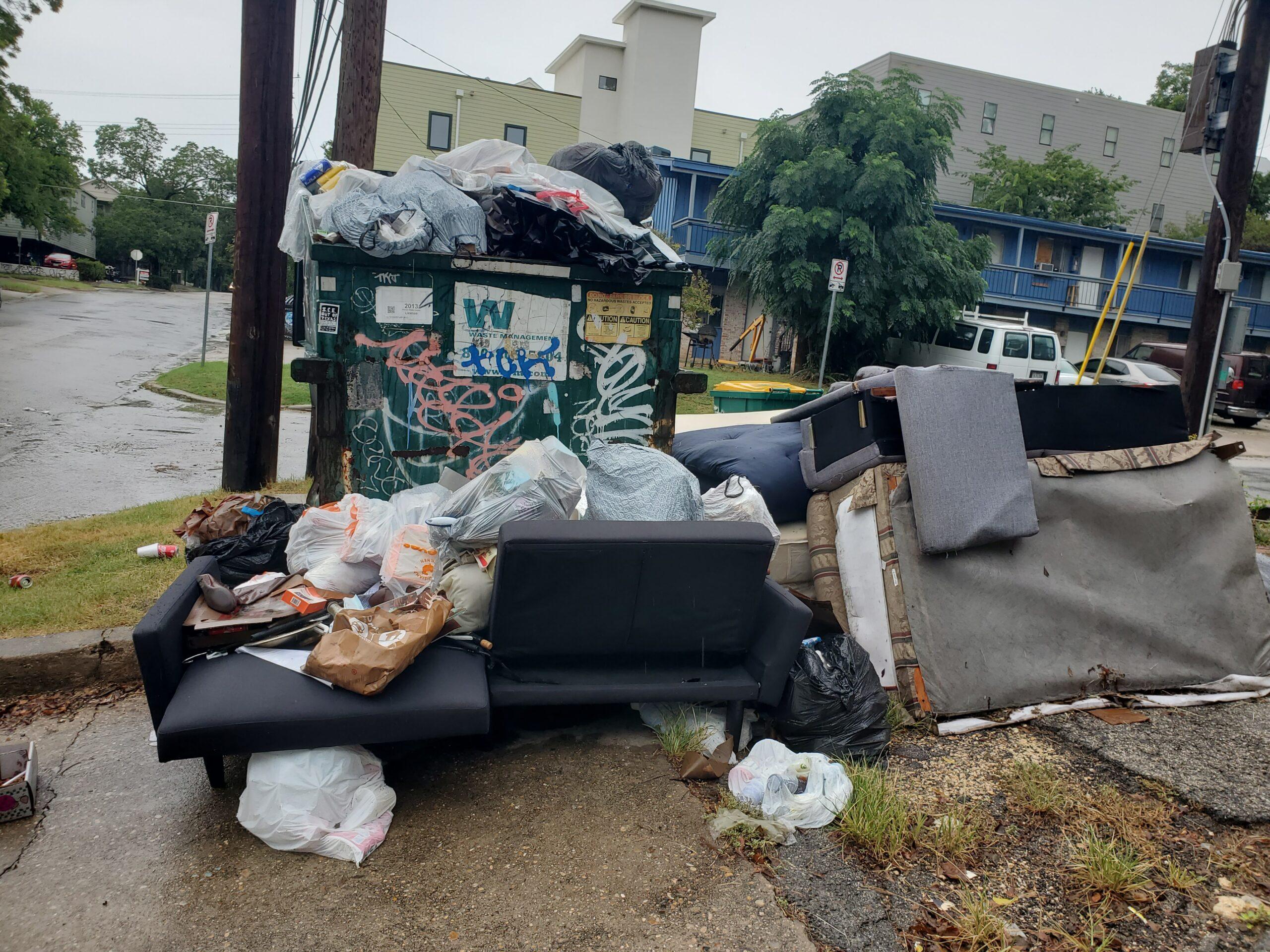 Austin student campus living trash junk by dumpsters