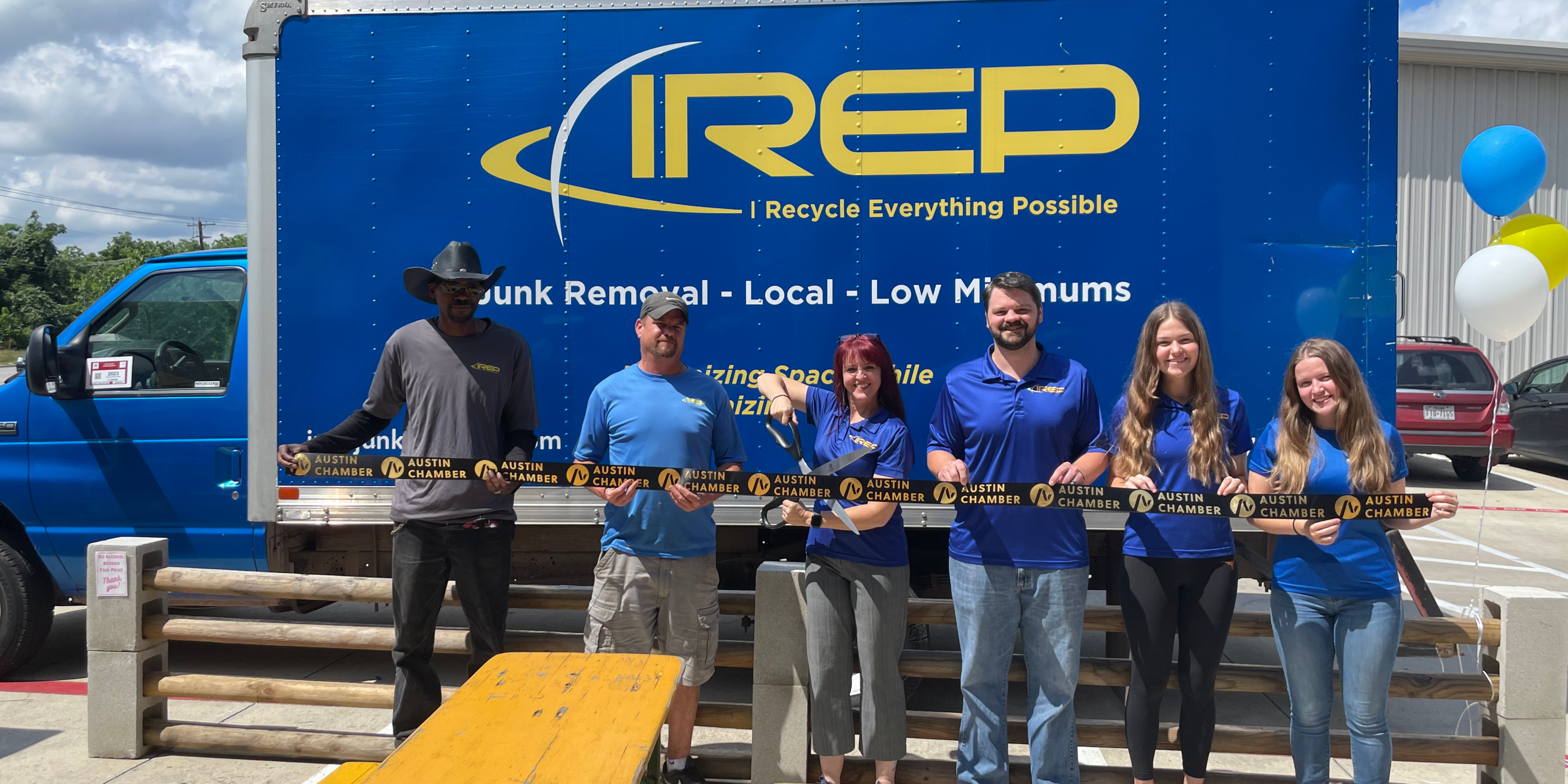 IREP Junk Removal Staff by the IREP box truck holding and cutting an Austin Chamber of Commerce ribbon